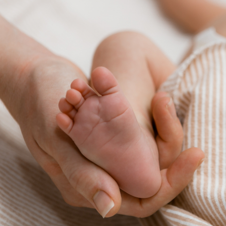 Hand holding infant foot Hand holding infant foot
